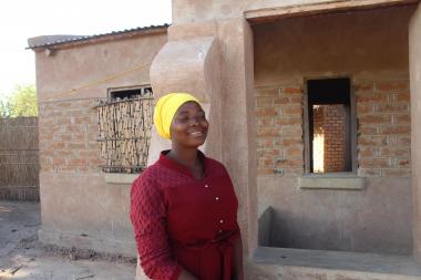 Chikaonda standing in front of her renovated house
