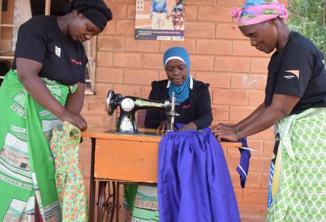 Mkumba Support Mother Group members sewing clothes for needy children and for sale