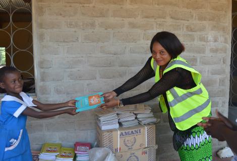 Kuchene Women Forum Director, Getrude Kaleso (Right) making a symbolic donation of books to learners at Thangazi One primary school