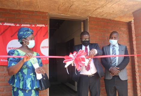 CEED Manager, Billy Banda (flanked by ActionAid Malawi Vice Chairperson, Professor Dorothy Nampota, and Senior Chief Kasakula  cutting the ribbon to mark the official opening of the hostel