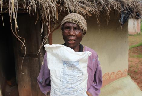 Ronans Chipeta holding a bag of flour she bought using Cash Transfer money