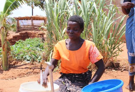 Ngulube draws water from a recently installed water tap