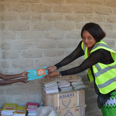Kuchene Women Forum Director, Getrude Kaleso (Right) making a symbolic donation of books to learners at Thangazi One primary school