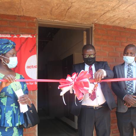 CEED Manager, Billy Banda (flanked by ActionAid Malawi Vice Chairperson, Professor Dorothy Nampota, and Senior Chief Kasakula  cutting the ribbon to mark the official opening of the hostel