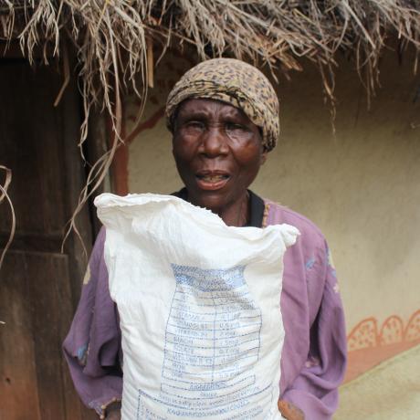 Ronans Chipeta holding a bag of flour she bought using Cash Transfer money
