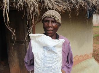 Ronans Chipeta holding a bag of flour she bought using Cash Transfer money