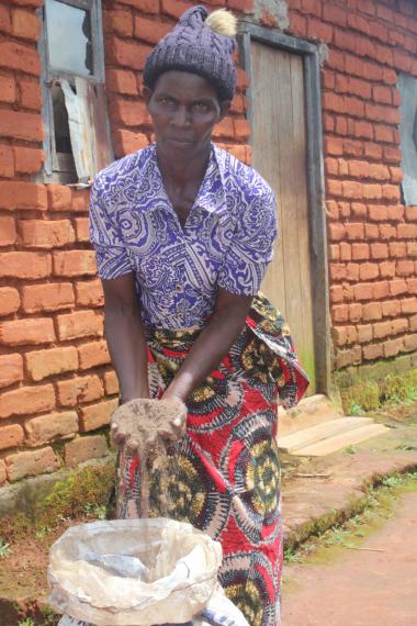 Catherine Banda demonstrating how organic fertilizer is made