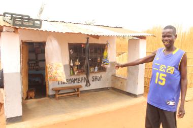 Shadrack Banda pointing at the shop she has built